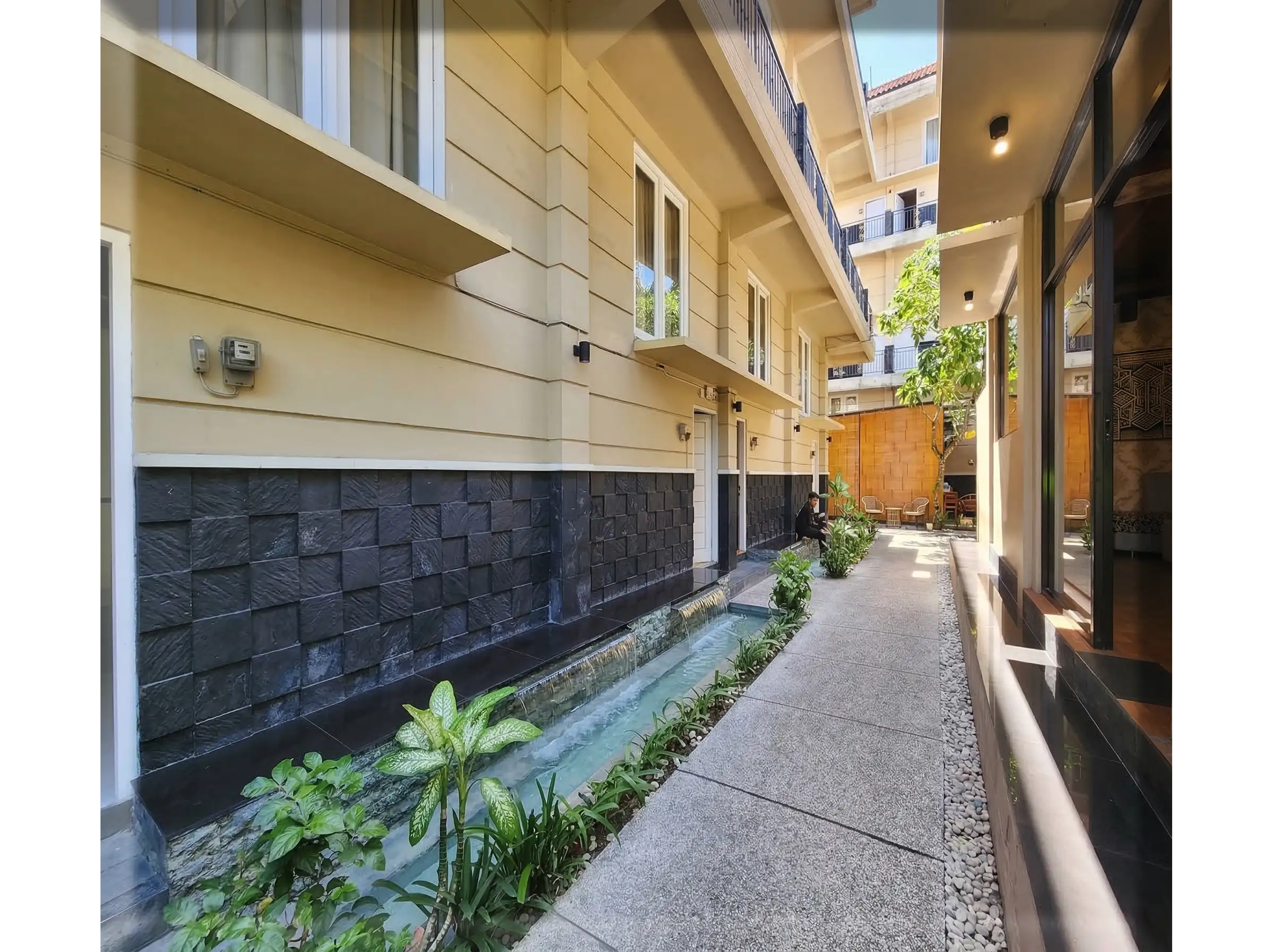 massage plus bali, Koridor tenang menuju kamar perawatan di RPS Spa Bali dengan dekorasi dinding minimalis dan pencahayaan hangat.